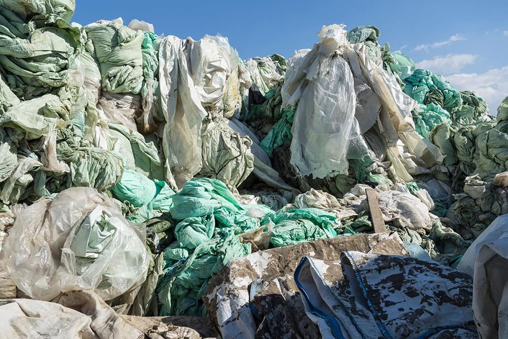 Bales of used, mixed and dirty plastic film waiting for recycling