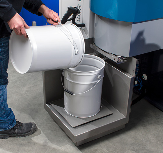 Operator adding ink manually to the Colorsat Slim sliding weighing scale